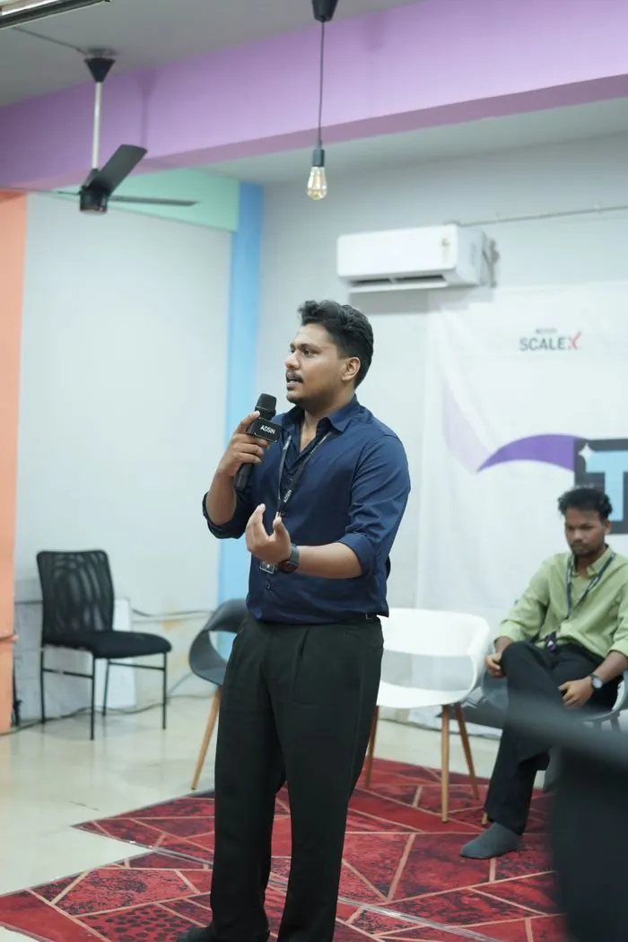 Jasim CP speaking with a microphone at an Adsin team event